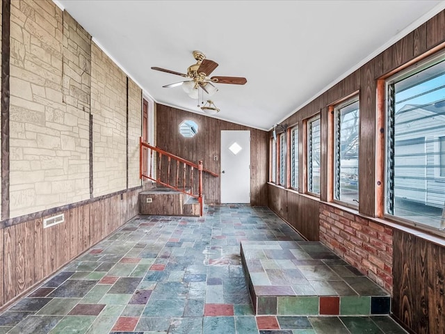 unfurnished sunroom featuring ceiling fan