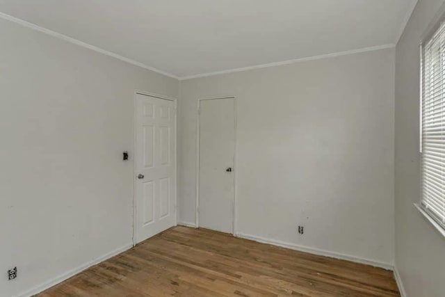 empty room with hardwood / wood-style flooring and ornamental molding