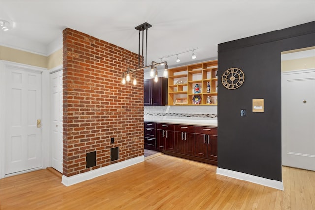 kitchen with pendant lighting, tasteful backsplash, and light wood-type flooring