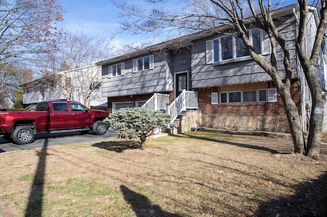 split foyer home featuring a garage and a front yard