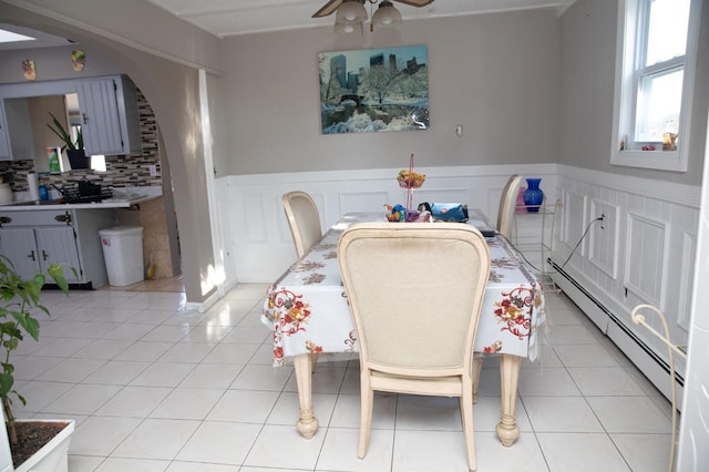 tiled dining room featuring a baseboard radiator and ceiling fan