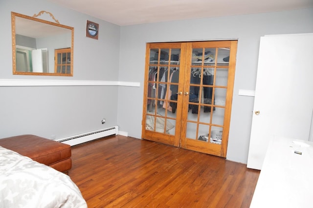 bedroom with baseboard heating, dark wood-type flooring, and french doors