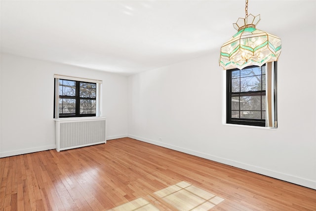 spare room with radiator and light wood-type flooring