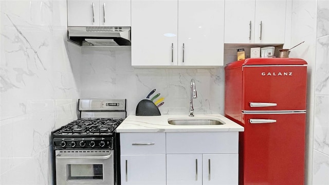 kitchen featuring white cabinetry, gas range, fridge, and sink