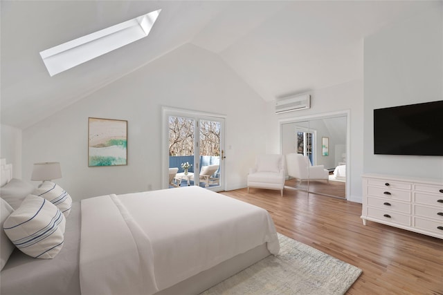 bedroom with wood-type flooring, access to outside, a wall mounted AC, and vaulted ceiling with skylight