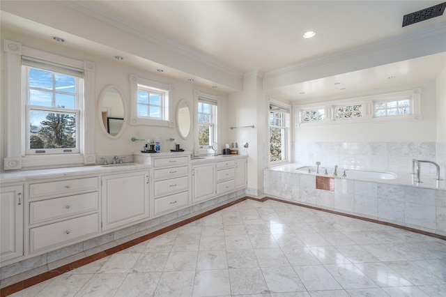 bathroom featuring tiled bath, vanity, crown molding, and a wealth of natural light