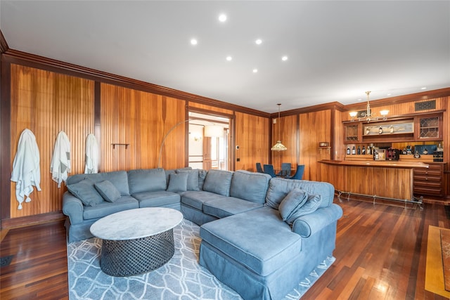 living room featuring crown molding, dark hardwood / wood-style floors, and wooden walls