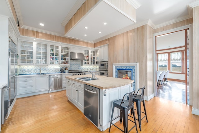 kitchen featuring a center island with sink, white cabinetry, sink, and appliances with stainless steel finishes