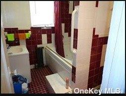 bathroom featuring sink, tile walls, tile patterned floors, and washtub / shower combination