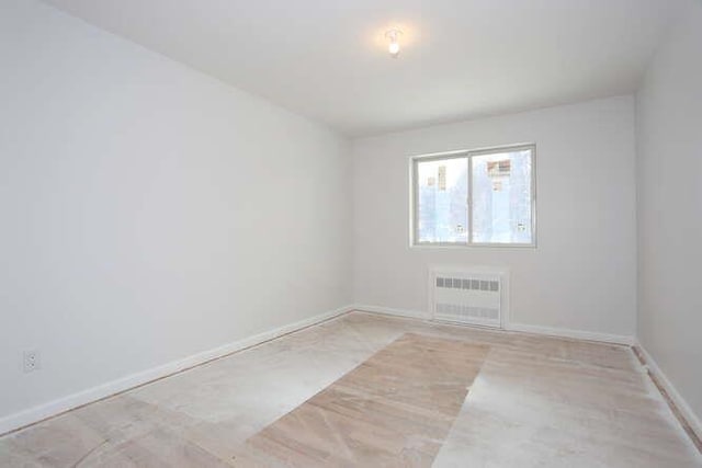 spare room featuring radiator heating unit and baseboards