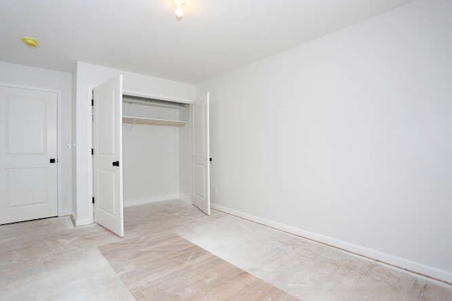 unfurnished bedroom featuring baseboards and a closet