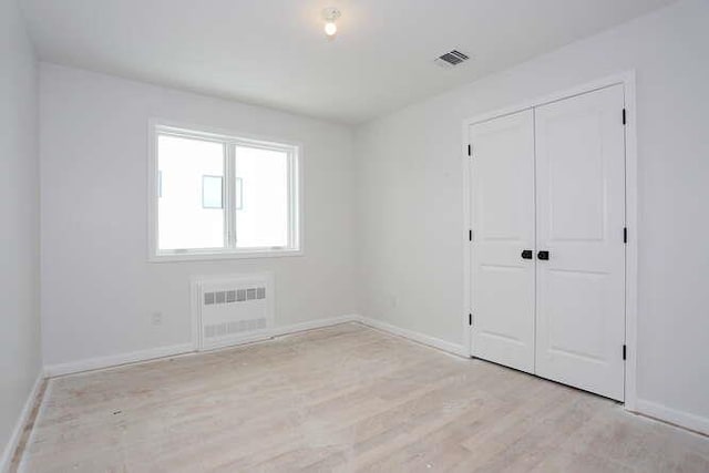 unfurnished bedroom featuring light wood-style floors, a closet, visible vents, and baseboards