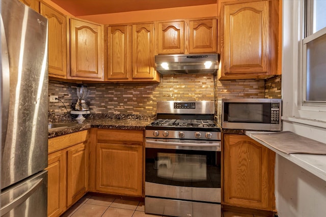 kitchen featuring light tile patterned floors, backsplash, and stainless steel appliances