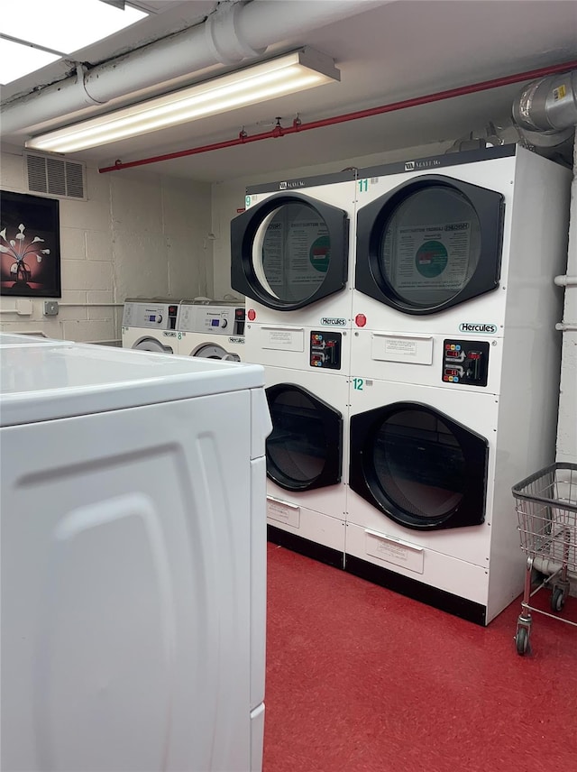 washroom with stacked washer and dryer and washing machine and clothes dryer