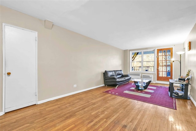 sitting room with a wall unit AC, radiator, and light hardwood / wood-style floors