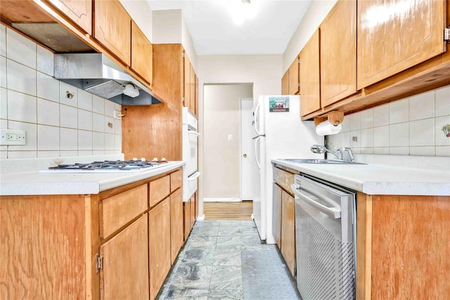 kitchen with tasteful backsplash, white appliances, and sink