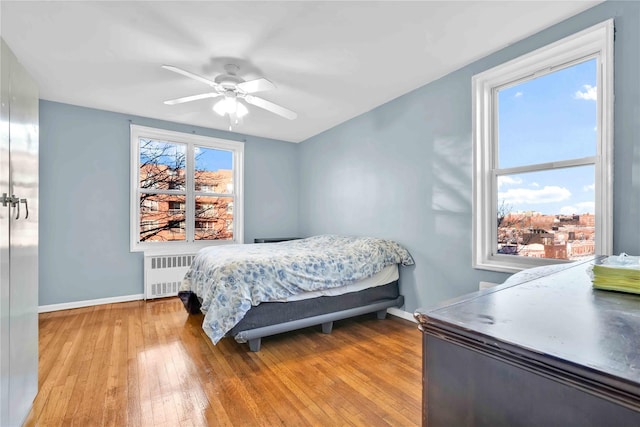 bedroom with radiator, ceiling fan, and light hardwood / wood-style flooring