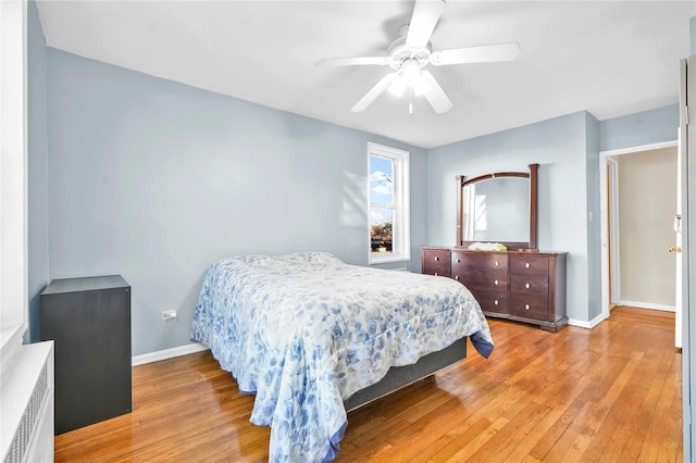 bedroom featuring ceiling fan, radiator, and light wood-type flooring