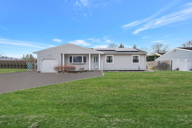 ranch-style house featuring a garage, a front lawn, and solar panels