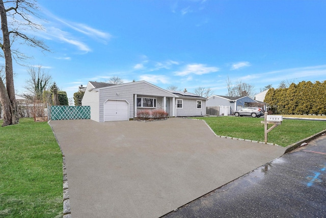 single story home featuring a garage, a front yard, and solar panels