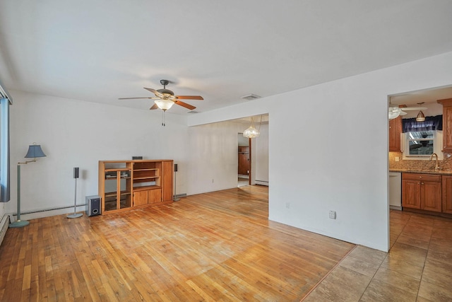 living room featuring a baseboard heating unit, sink, ceiling fan, and light hardwood / wood-style flooring