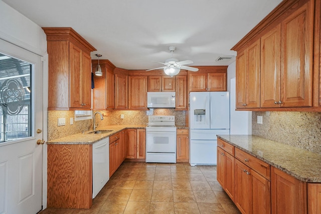 kitchen with light tile patterned flooring, sink, light stone counters, hanging light fixtures, and white appliances