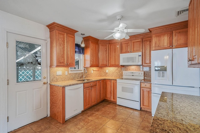 kitchen with white appliances, light stone countertops, sink, and backsplash