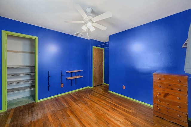 unfurnished bedroom featuring dark hardwood / wood-style flooring, a closet, and ceiling fan