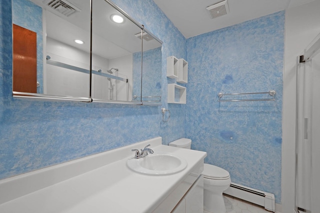 bathroom with a shower with door, vanity, a baseboard heating unit, and toilet