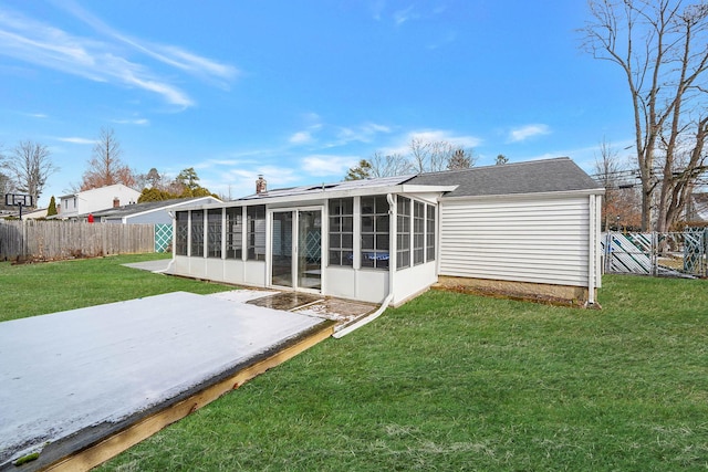 back of property with a patio area, a sunroom, and a lawn