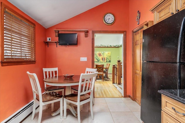 tiled dining room featuring lofted ceiling and a baseboard radiator