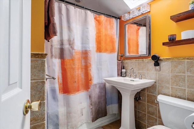 bathroom featuring tile walls and toilet