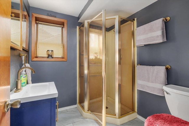 bathroom with vanity, toilet, and a shower with shower door