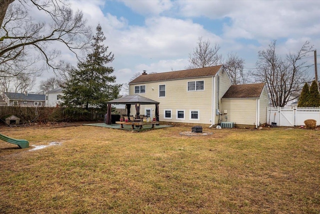 rear view of house featuring a gazebo, a yard, an outdoor fire pit, and a patio