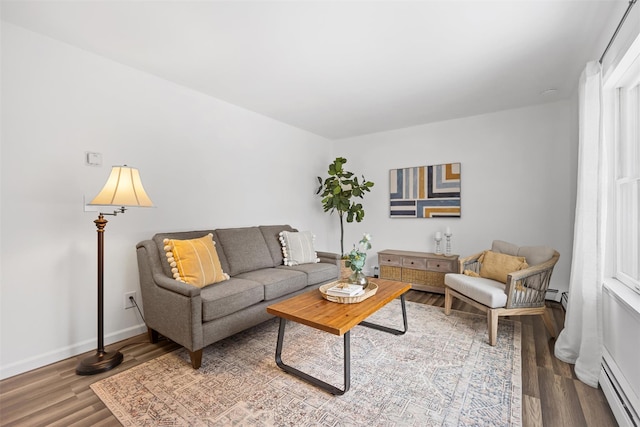 living room with wood-type flooring and a baseboard heating unit