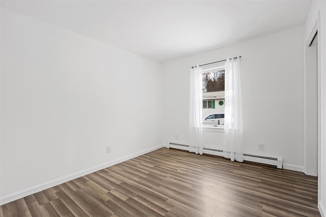 unfurnished room featuring dark hardwood / wood-style floors and baseboard heating