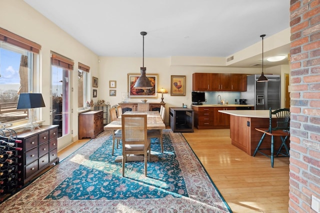 dining room with sink and light hardwood / wood-style flooring