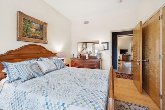 bedroom featuring vaulted ceiling and light wood-type flooring