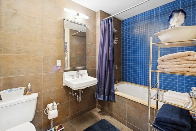 full bathroom with sink, tile walls, toilet, shower / bathtub combination with curtain, and tile patterned floors