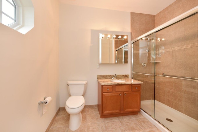 bathroom with tile patterned flooring, vanity, toilet, and walk in shower