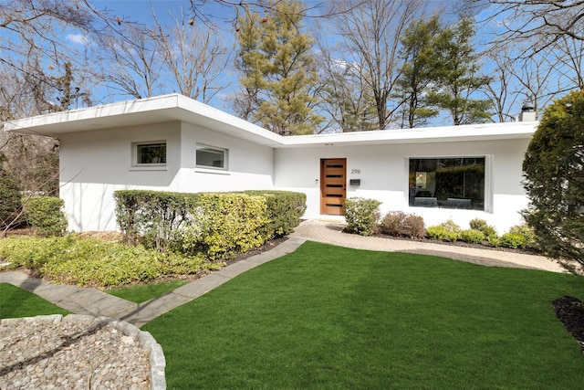 view of front of property featuring a front lawn and stucco siding