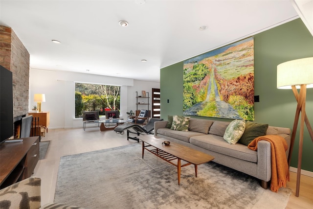 living room with baseboards, wood finished floors, and a fireplace