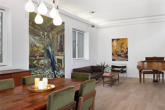 dining space with baseboards and light wood-style floors