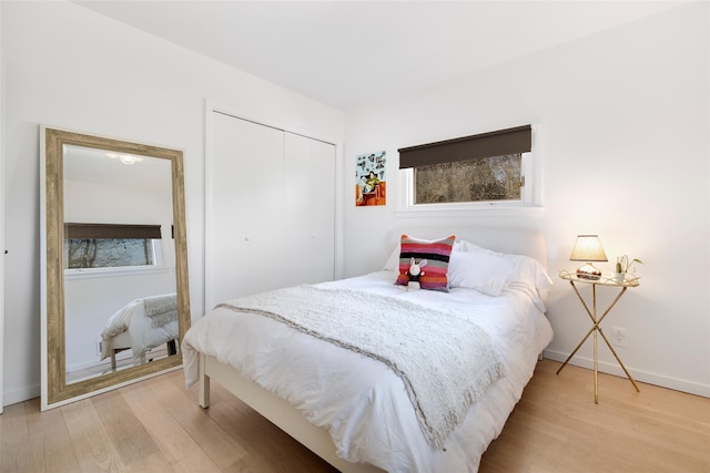 bedroom featuring light wood-style floors, a closet, and baseboards