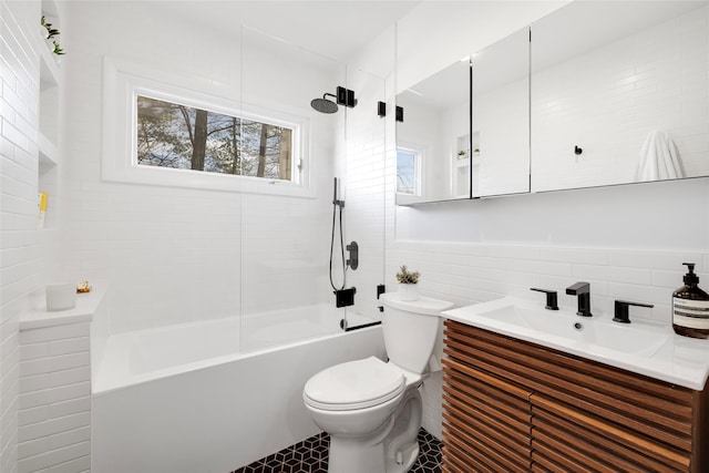 full bathroom with toilet, vanity, tile walls, and shower / bathtub combination