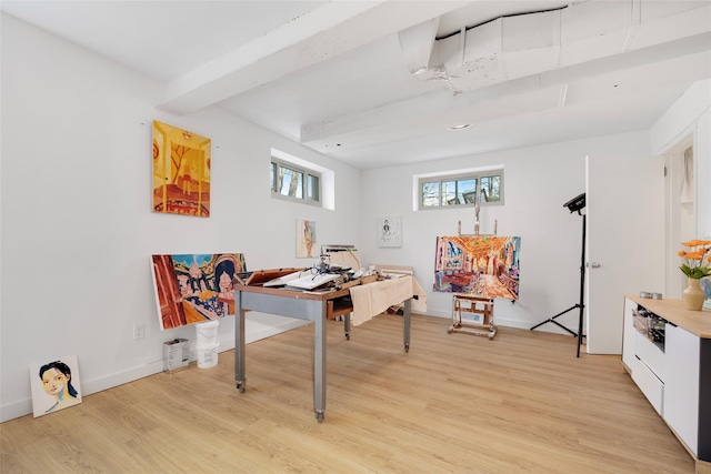 recreation room featuring beamed ceiling, baseboards, and light wood-style floors