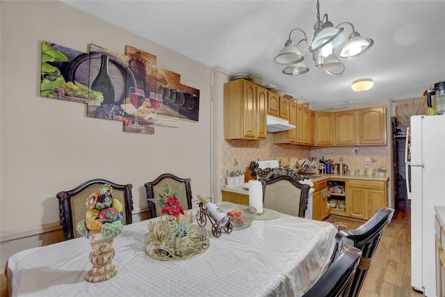 dining room with an inviting chandelier and light hardwood / wood-style flooring