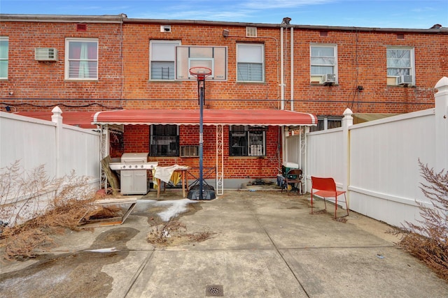 back of house with cooling unit, a wall mounted AC, and a patio area