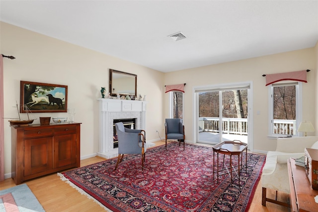 living room with a fireplace and light wood-type flooring