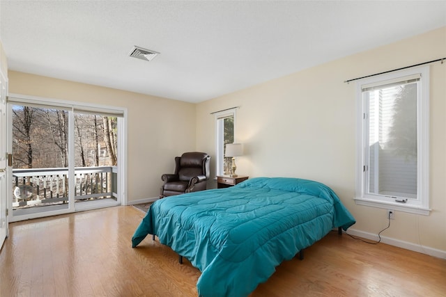 bedroom with access to exterior and light wood-type flooring